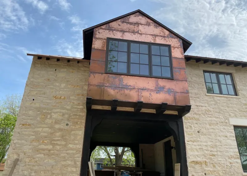 Copper metal panel facade on a stone building for Metal Roof Coating in Clay