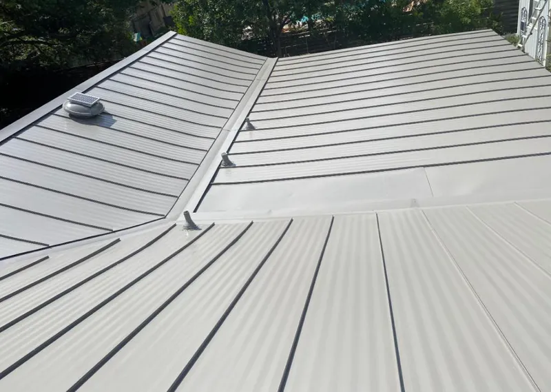 Solar attic fan installed on a metal roof for Roof Ventilation in Clay